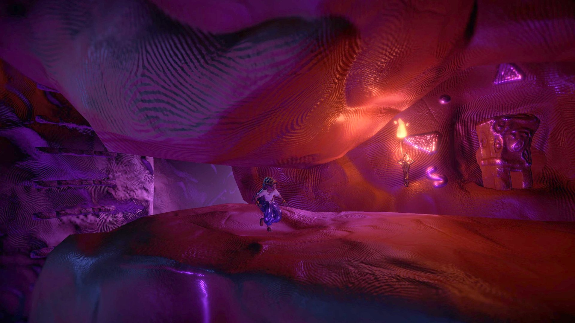 Halima running past a torch in the caves